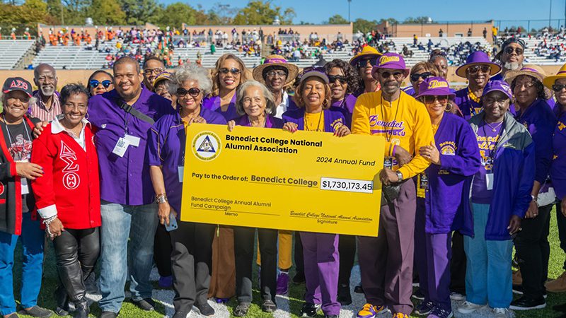 A group representing benedict college holding a large check