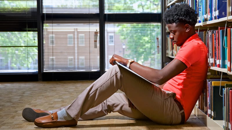 Male Morris College student studying in a library