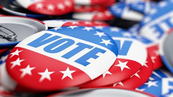 Pile of lapel pin buttons that say vote