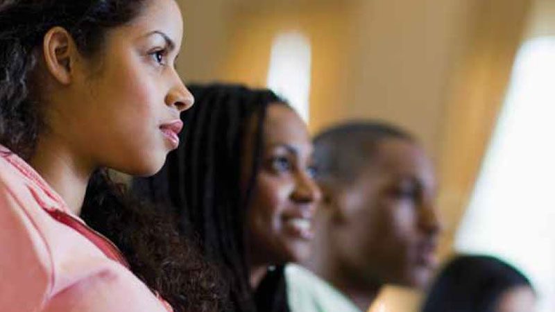 a group shot of four students watching an event