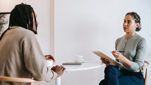 Ethnic female psychotherapist listening to black clients explanation