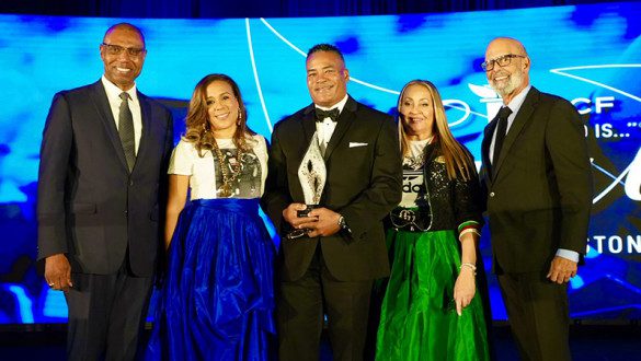 Dr. Lomax and four attendees pose together onstage
