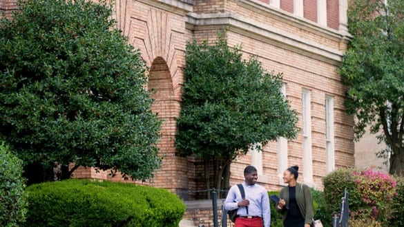 Male and female Lane College students walking on campus outside talking