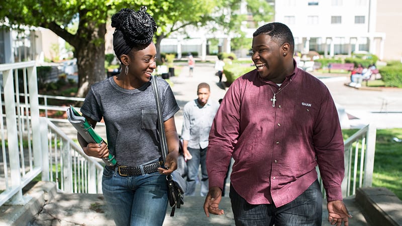 2 Shaw University students talking and laughing outside on campus