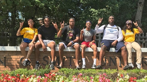 Students sitting on Johnson C. Smith University sign outside