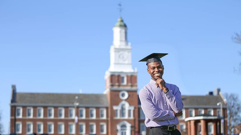 Male Rust College student smiling outside building