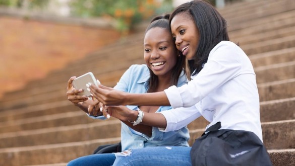 Two female college students talking on a cell phone