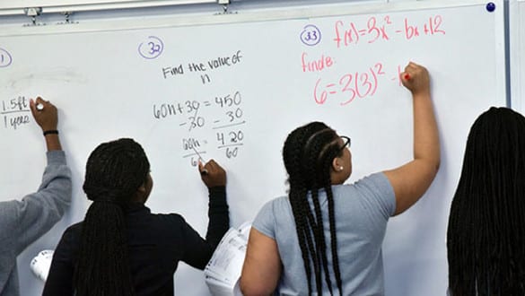 spellman students at whiteboard doing math