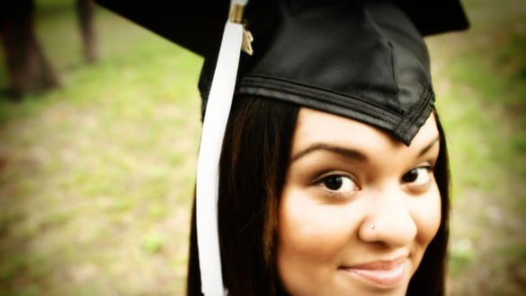 Headshot of female college graduate wearing cap and gown