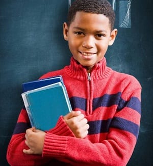 Male young elementary school student holding books